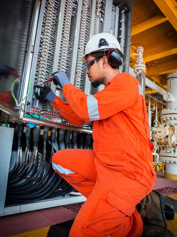 Electrical and instrument technician troubleshooting on programmable logic controller of oil and gas production system